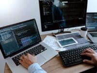 Laptop moderna utilizada por programador en ambiente laboral