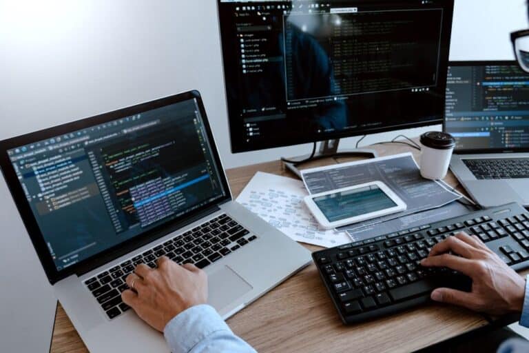Laptop moderna utilizada por programador en ambiente laboral